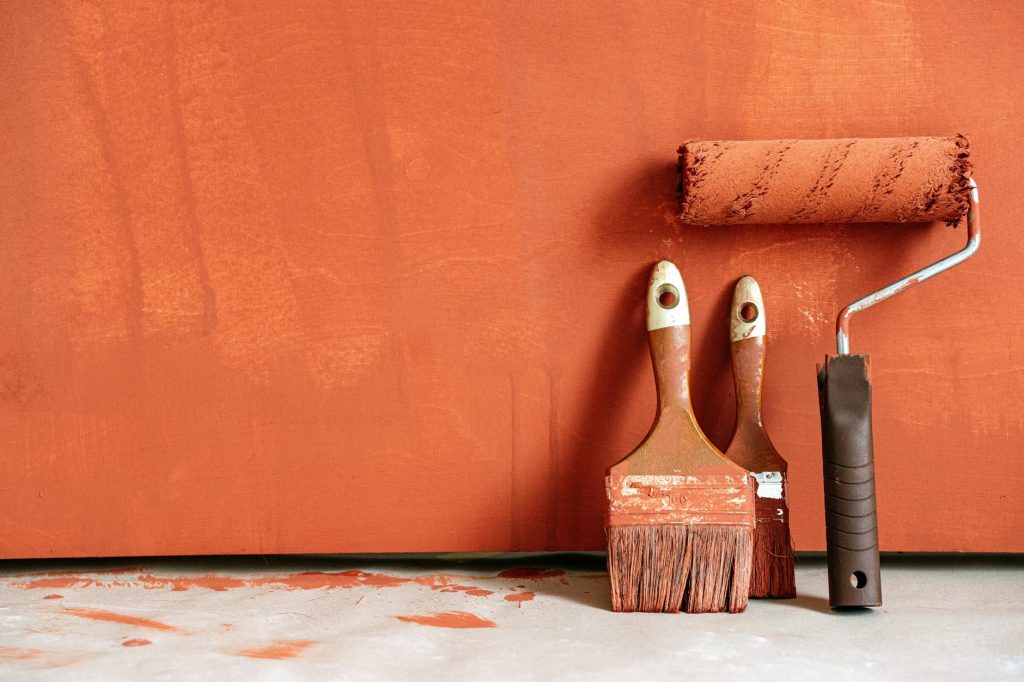 close up shot of variety of paintbrushes with orange paint