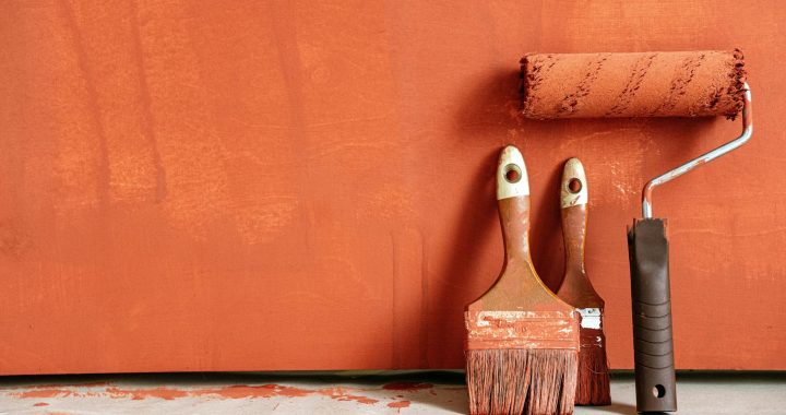 close up shot of variety of paintbrushes with orange paint